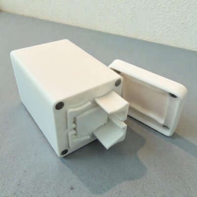 A compact, 3D-printed white travel case for DomiGo portable dominoes, showing the open lid and durable modular design.