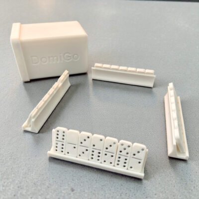 A compact, 3D-printed white travel case for DomiGo portable dominoes, showing the open lid and durable modular design.